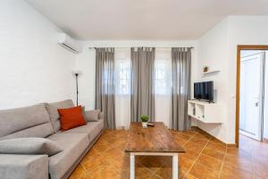 uma sala de estar com um sofá e uma mesa em Apartamento Jibazahora B3 em Zahora