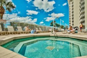 a swimming pool at a resort with people sitting on chairs at Majestic Sun 1108B in Destin