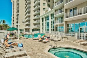 a resort with a swimming pool and people sitting in chairs at Majestic Sun 1108B in Destin