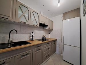 a kitchen with wooden cabinets and a white refrigerator at Noclegi u Kazi in Polańczyk