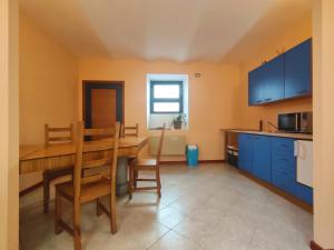 kuchnia z drewnianym stołem i niebieskimi szafkami w obiekcie L'Uovo di Colombo w mieście Omegna