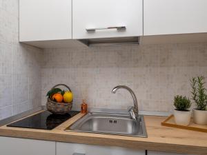 a kitchen with a sink and a basket of fruit at Palazzo Russo - De Vivo Realty Piano di Sorrento in Piano di Sorrento +57 photos