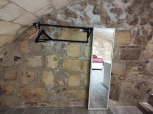 a room with a mirror and a stone wall at Au 47 in Bordeaux