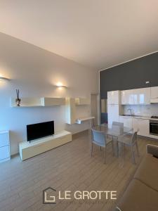 una cucina e un soggiorno con tavolo e sedie di Tramonto - Le Grotte Rooms & Apartments a Camerano