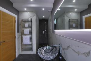 a bathroom with a large mirror and a sink at Glass Island Ballycastle in Ballycastle