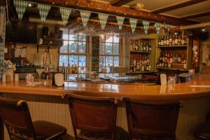 a bar with three chairs and a counter with alcohol at Franconia Inn in Franconia