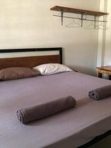 a bed with two pillows on top of it at Macondo in Koh Rong Sanloem