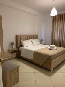 een slaapkamer met een groot bed en 2 handdoeken bij Mediterranean Apartments in Himare