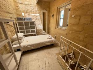 Habitación pequeña con cama y ventana en Charming 200 year old cottage with yard, en Żabbar