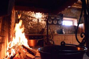 ein Feuer in einer Küche mit einem Topf und einem Herd in der Unterkunft Chalet La Rite Dolomiti in Masariè