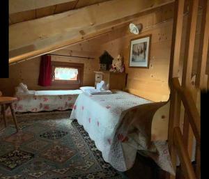 um quarto com 2 camas num chalé de madeira em Chalet La Rite Dolomiti em Masariè