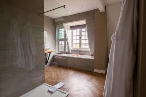 a bathroom with a shower with a tub and a window at Hotel Inn Naeldwyk-Torenburg in Naaldwijk +46 photos
