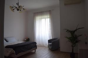 sypialnia z łóżkiem, krzesłem i oknem w obiekcie Residenza Lo Bello Vedere w mieście Caserta +37 zdjęć
