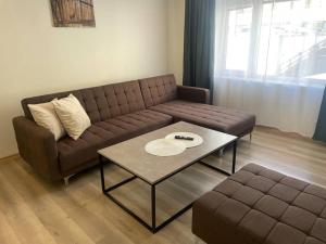 un soggiorno con divano marrone e tavolo di 3 rooms apartment in Center ad Ålesund