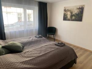 a bedroom with a bed with a chair and a window at 3 rooms apartment in Center in Ålesund