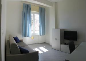 a living room with a couch and a television at Lungomare Apartments in Arma di Taggia