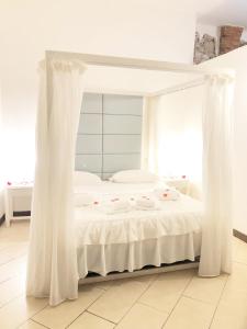 a white bed with white curtains in a room at Suite In Love 21 in Casale Marittimo