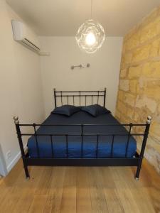 um quarto com uma cama e um lustre em Au 47 em Bordeaux