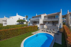 a villa with a swimming pool and a house at Vale Do Lobo Resort in Vale do Lobo