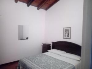 ein Schlafzimmer mit einem Bett in einem weißen Zimmer in der Unterkunft Rifugio Mareneve le Villette in Linguaglossa