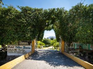een poort naar een weg met bomen en een hek bij Villas El Paraiso in Tlaquiltenango