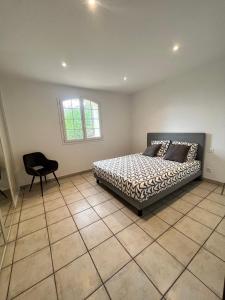 - une chambre avec un lit et une chaise dans l'établissement Appartement haut de Villa, à La Valette-du-Var