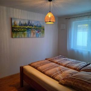 twee bedden in een kamer met een schilderij aan de muur bij Ferienwohnung Ahornweg in Ihrlerstein