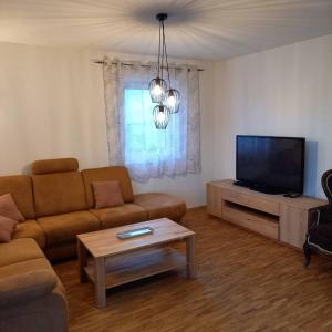 a living room with a couch and a flat screen tv at Ferienwohnung Ahornweg in Ihrlerstein