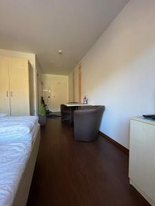 a bedroom with a bed and a desk and a table at Küstenapartment 2 in Gelbensande
