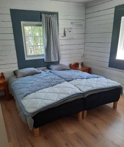 a bedroom with a large bed with a window at Davids Stuga in Klässbol