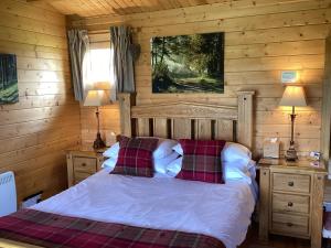 um quarto com uma cama num chalé de madeira em Auchenlea lodges em Glasgow