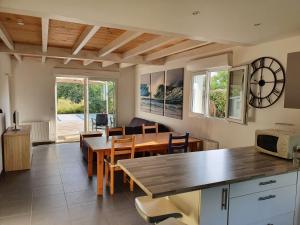 eine Küche und ein Esszimmer mit einem Tisch und Stühlen in der Unterkunft Maison à Tosse avec vue sur la nature in Tosse