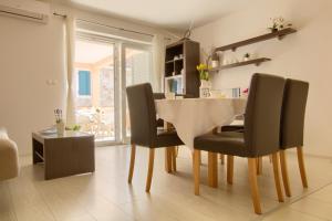 une salle à manger avec une table et des chaises blanches dans l'établissement Sea Breeze Suite - Beachfront, à Kali