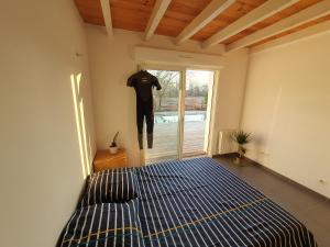 ein Schlafzimmer mit einem Bett und einem an der Wand hängenden Hemd in der Unterkunft Maison à Tosse avec vue sur la nature in Tosse