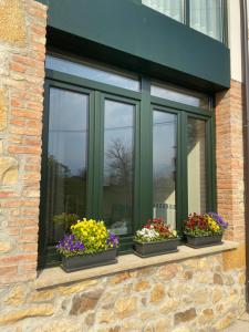 ein Fenster mit drei Blumentöpfen darauf in der Unterkunft Rincón de picos in Cangas de Onís + 6 Fotos