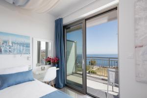 1 dormitorio con cama y vistas al océano en Contessina del mare en Panormos Rethymno
