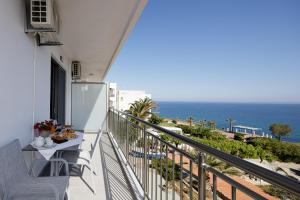 balcón con mesa, sillas y vistas al océano en Contessina del mare en Panormos Rethymno