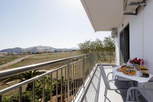 a balcony with a table with a plate of food at Contessina del mare in Panormos Rethymno