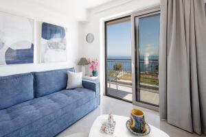 a living room with a blue couch and a large window at Contessina del mare in Panormos Rethymno +15 photos