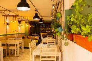 un ristorante con tavoli e sedie in legno e piante di HBS Hotel a Manizales