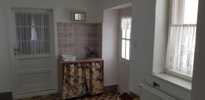 a bathroom with a door and a sink and a window at Hortenzia Vendégház Márianosztra in Márianosztra +24 photos