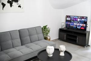 - un salon avec un canapé et une télévision dans l'établissement Casa De Lago, à Agios Nikolaos