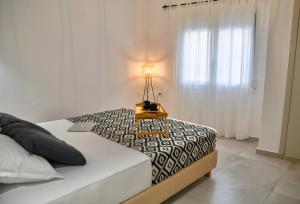 a bedroom with a bed with a table with a lamp on it at Casa De Lago in Agios Nikolaos