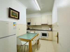 uma pequena cozinha com uma mesa e um frigorífico em La plaza apartment em San Sebastián