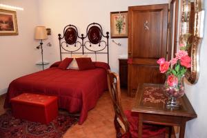 スペッロにあるAntiche Dimore San Feliceのベッドルーム1室(ベッド1台、花瓶付きのテーブル付)