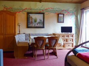 a living room with a table and chairs and a television at Stinglhof in Železná Ruda