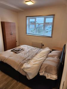 a large bed in a bedroom with a window at Peace House in Streatham Vale