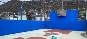 una camera blu con panchina e parete blu di Nomada Hostel Oaxaca - Vive nómada! a Città di Oaxaca Altre 23 foto