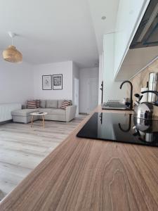 a white living room with a kitchen and a table at Przystań Natura Apartamenty nad rzeką, cisza i rowery in Iława