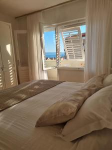 a bedroom with a bed with a view of the ocean at Apartments Ema near beach in Makarska